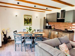 a kitchen and a living room with a table and chairs at Green Hills - Holiday Home & Events in Kamenica