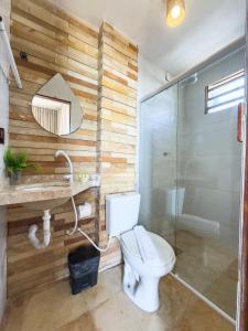 a bathroom with a toilet and a shower and a mirror at Pousada Mahalo Preá Beach in Prea