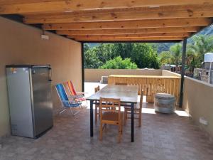 a patio with a table and chairs and a refrigerator at El Belichito in Belén