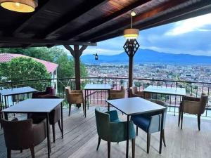 a patio with tables and chairs and a view of a city at Hotel Berati in Prizren