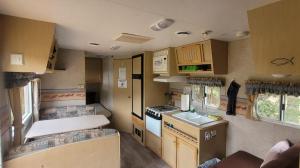 a small kitchen in an rv with wooden cabinets at RV with Rocky Mountains View in McBride
