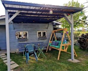 a pergola with a swing and a playground at CHAMBRES chez nous Sorties A62 6 ou 6 1 in Saint-Laurent