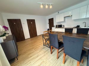 a kitchen and dining room with a table and chairs at Air AMBER PEN LOTNISKO parking in Kaszów
