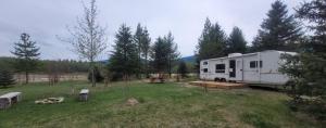a white trailer parked in a field with trees at RV with Rocky Mountains View in McBride +12 photos