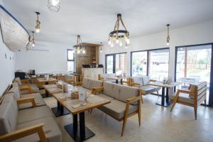 a restaurant with tables and chairs and windows at Danube Delta Bungalows Gorgova in Gorgova