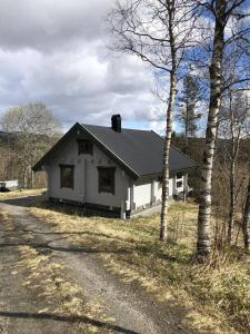 a white house on the side of a road at Timber cabin, centrally located in Bodø in Bodø