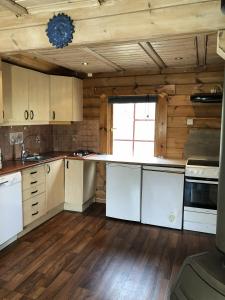a kitchen with wooden walls and white cabinets and a counter at Timber cabin, centrally located in Bodø in Bodø