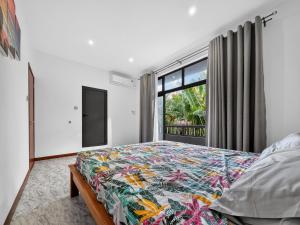 a bedroom with a large bed and a window at Spacious Pereybere 3BR Apartment in Grand-Baie
