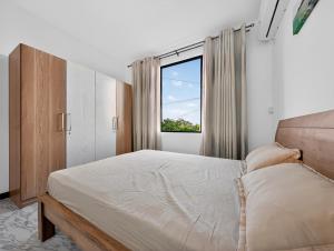 a bedroom with a large bed and a window at Spacious Pereybere 3BR Apartment in Grand-Baie