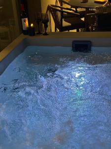 a hot tub filled with blue water next to a table at Artion Jacuzzi Villa Nikiti in Nikiti