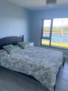 a bedroom with a bed and a large window at Tigh an Trá in Bantry