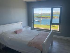 a bedroom with a bed and a large window at Tigh an Trá in Bantry