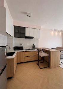 a kitchen with wooden cabinets and a table and a refrigerator at Oderm one bedroom apartment in Syokimau near jkia airport and sgr station in Nairobi in Nairobi