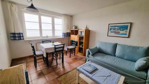 a living room with a couch and a table at Ferienwohnung Soling - ideal für Paare, mit Wasserblick in Alt Reddevitz