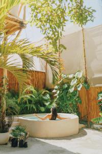 a woman sitting in a bath tub in a garden at Casa Balam Holbox, Beach style cabañas in Holbox Island +50 photos