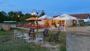 a group of chairs and tables in front of a restaurant at Camping Mitrov in Strážek