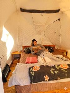 a woman laying on a bed in a tent at Friends glamping & Sauna in Kutaisi +16 photos