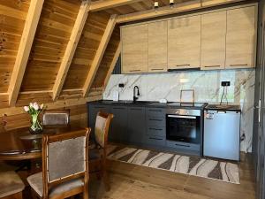 a kitchen with a stove and a table with chairs at LakeSideCottage in Plav +4 photos