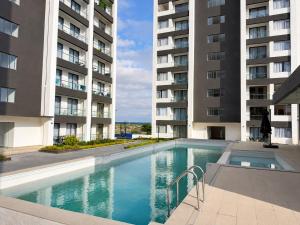 a swimming pool in front of two tall buildings at Oderm one bedroom apartment in Syokimau near jkia airport and sgr station in Nairobi in Nairobi