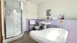 a bathroom with a tub and a toilet and a sink at Lochinver Manse in Lochinver +22 photos
