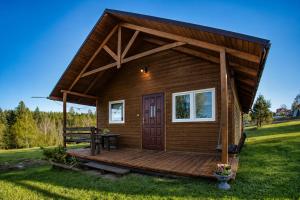 a small cabin with a wooden deck in a field at Domki u Henia i Anety in Werlas