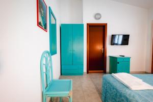 a bedroom with a blue cabinet and a blue chair at Villaggio Torre Ruffa Robinson in Capo Vaticano