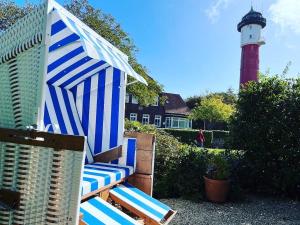 a blue and white beach umbrella and a lighthouse at Lighthousestudio & Spa- Exclusive Entspannt Besonders in Wangerooge