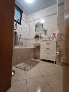 a bathroom with a sink and a tub and a mirror at Apartman Ajla in Bihać +24 photos