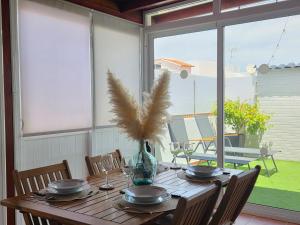 a wooden table with a vase with a plant on it at Roque`s House A in Telde