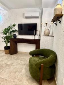 a living room with a green chair and a television at Casa Natali 1 in Fuengirola