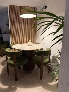 a table and some green chairs and a plant at Casa Natali 1 in Fuengirola +10 photos