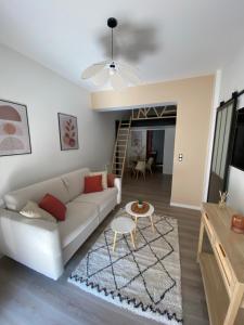 a living room with a white couch and a table at La Cabane Perché in Ault