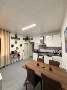 a kitchen and dining room with a wooden table and chairs at Amor Mosel Stay in Klotten