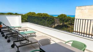a balcony with tables and chairs and the ocean at OMO STAYS Pinada Park in Guardamar del Segura
