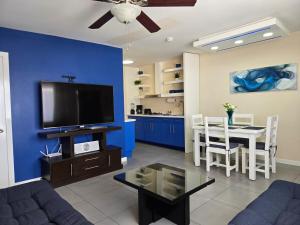 a living room with a tv and a dining room at Independent apartment in San Antonio