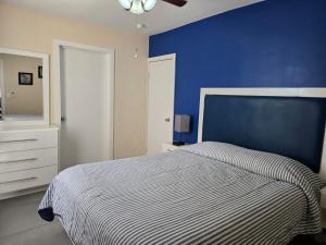 a bedroom with a bed with a blue wall at Independent apartment in San Antonio