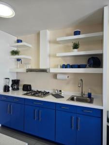 a kitchen with blue cabinets and a sink at Independent apartment in San Antonio