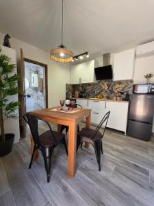 a kitchen with a wooden table and two chairs and a dining room at La Petite Finca in Elche