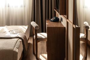 ein kleines Zimmer mit einem Bett, einem Schreibtisch und einem Tisch in der Unterkunft Darya-J in Athen