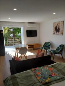 a living room with a couch and a table at The Hideaway in Raumati Beach +12 photos