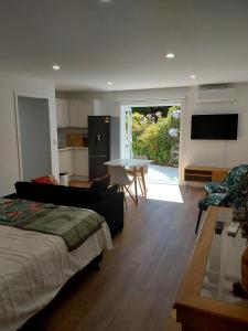 a room with a bed and a kitchen and a living room at The Hideaway in Raumati Beach
