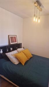 a bedroom with a bed with two pillows on it at Les Hautains in Saint-Genis-Pouilly