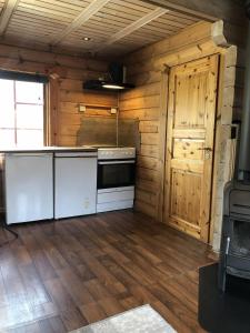 a kitchen with a stove and a wooden wall at Timber cabin, centrally located in Bodø in Bodø +14 photos
