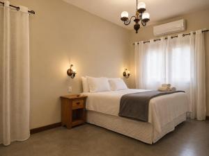 a bedroom with a large bed and a window at Pouso Alvorada in Tiradentes