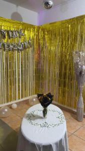 a room with a table with a vase and a yellow curtain at DYNAMIQUE ET SPLENDIDE in Bourgoin