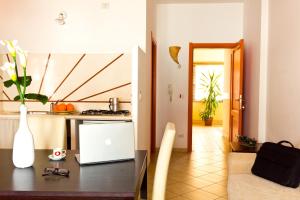 Marisal Accommodation في ألغيرو: مطبخ مع طاولة مع لاب توب عليها
