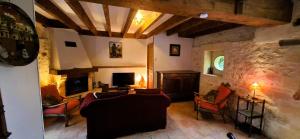a living room with couches and a fireplace at Coquelicots Dordogne in Saint-Julien-de-Lampon