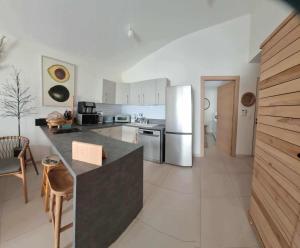 a kitchen with a refrigerator and a counter top at Villa Dérimbeault in Oyster Pond