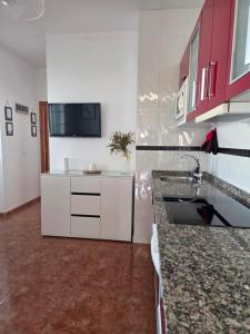 a kitchen with white cabinets and a counter top at Roque`s House A in Telde