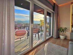 a balcony with two chairs and a view of a city at Luxury Apartment in Shkodër